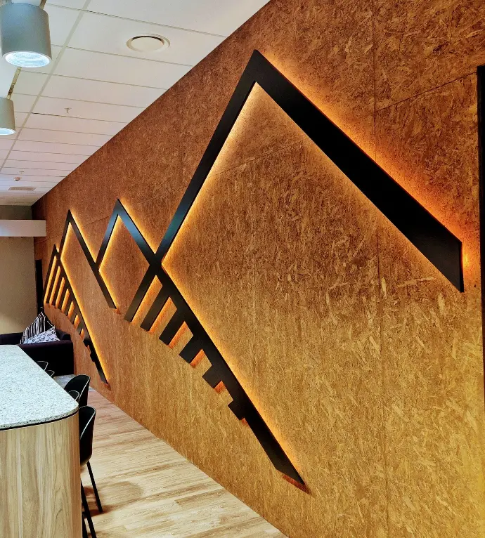 This backlit mountain wall graphic is mounted on a recycled wood wall to amplify a corporate office space.