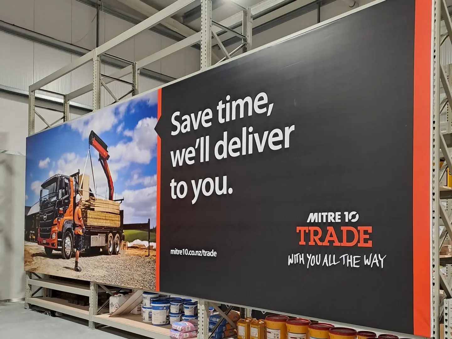 A large scale, vinyl banner attached to warehouse shelving at Mitre 10 Mega in the trade department.