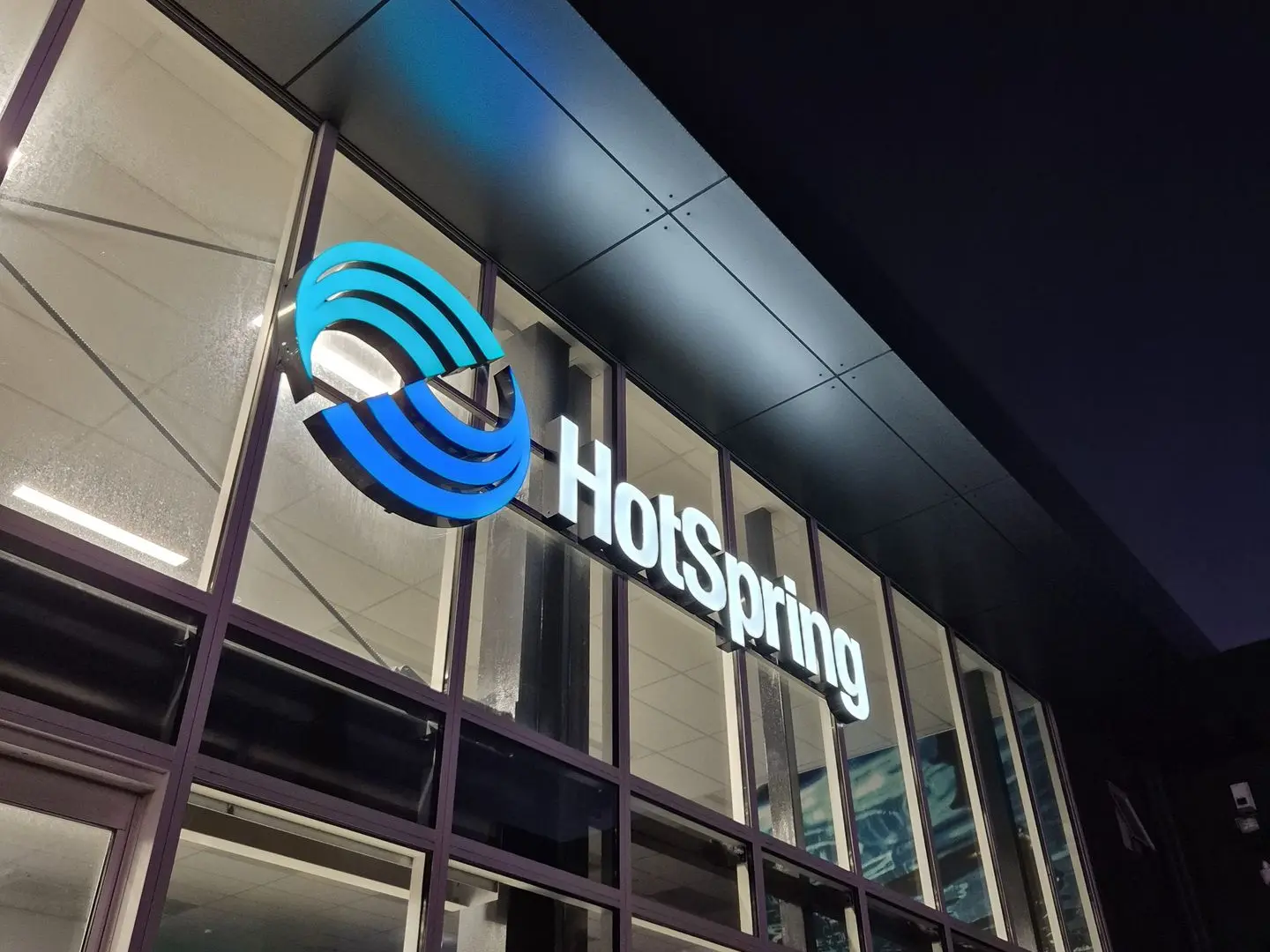Backlit illuminated logo sign on build exterior for Hot Springs Spa in Christchurch